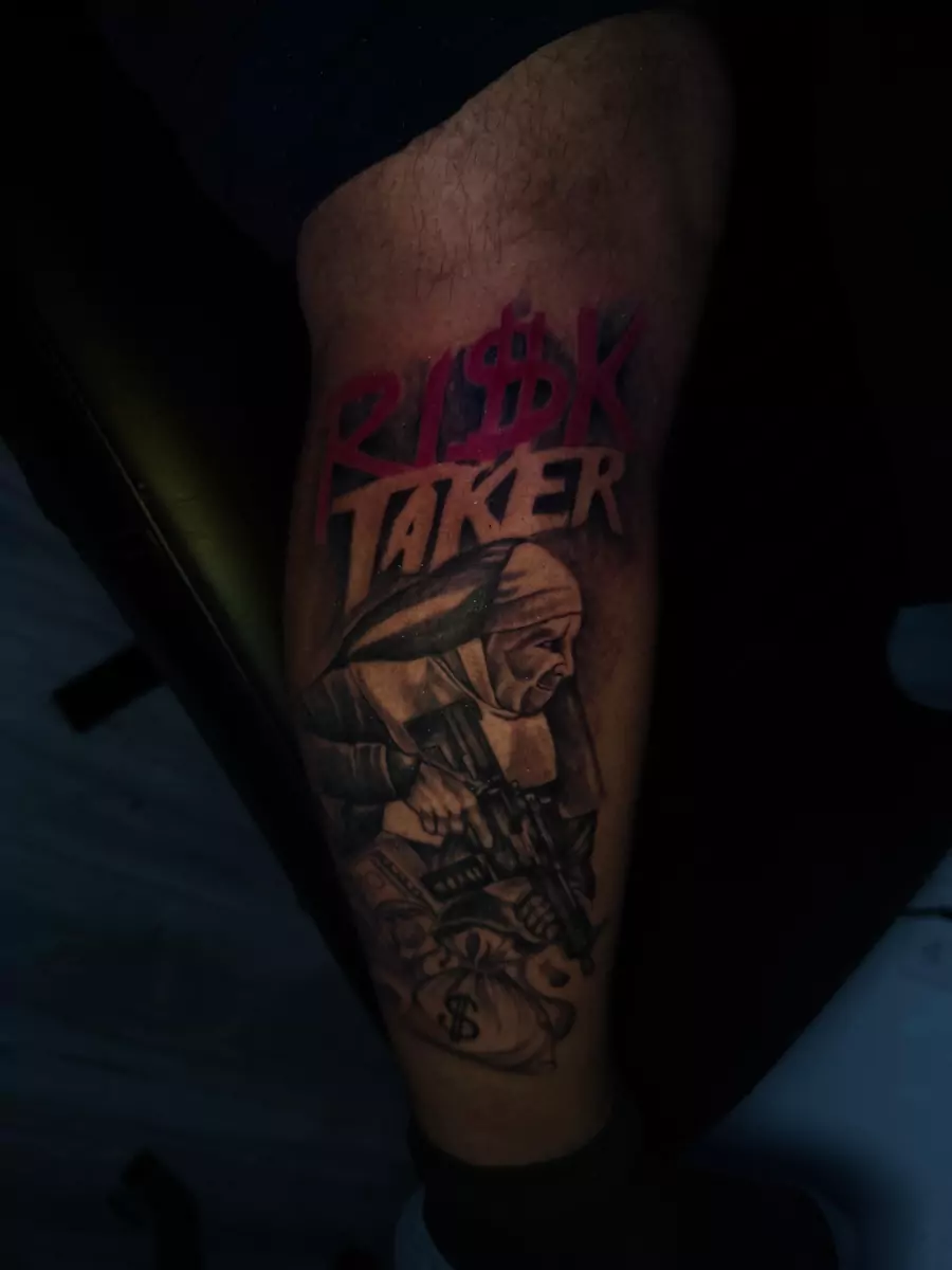 Bold red RISK TAKER lettering above a black and gray hooded figure on the thigh
