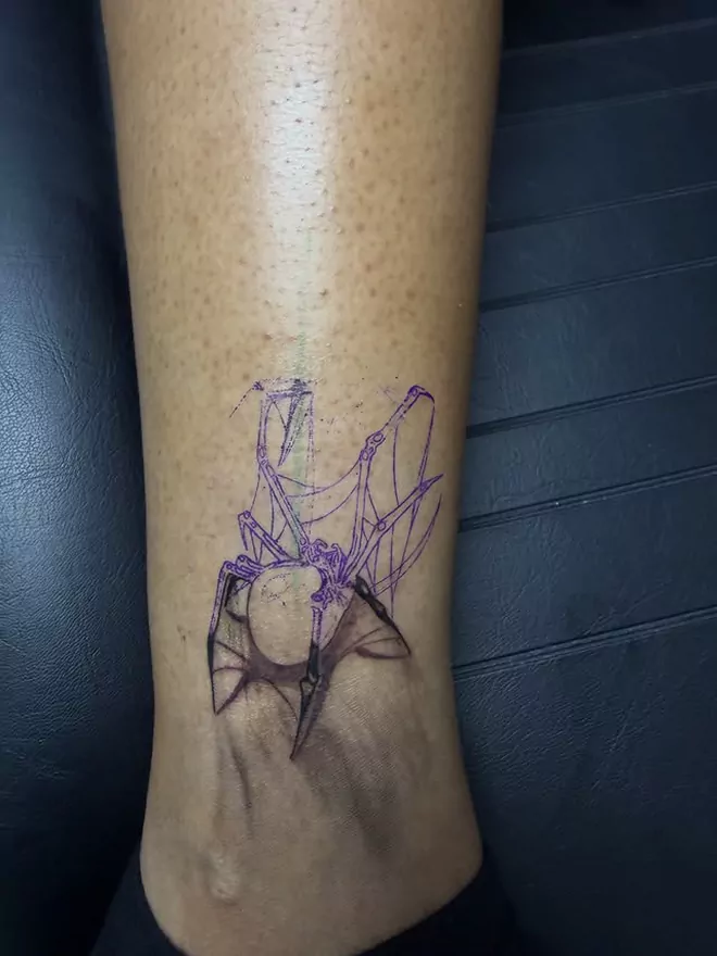 The black widow stencil in purple transfer ink on the ankle, the web mapped out and no black laid in yet